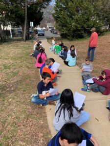 5th grade students share their Don Quixote essays outside on the sidewalk