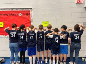 Math dice team poses with the back of their shirts